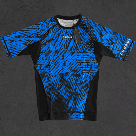 Blue and black patterned BJJ rash guard from CYPHR Combat's Enigma Series on a dark surface.