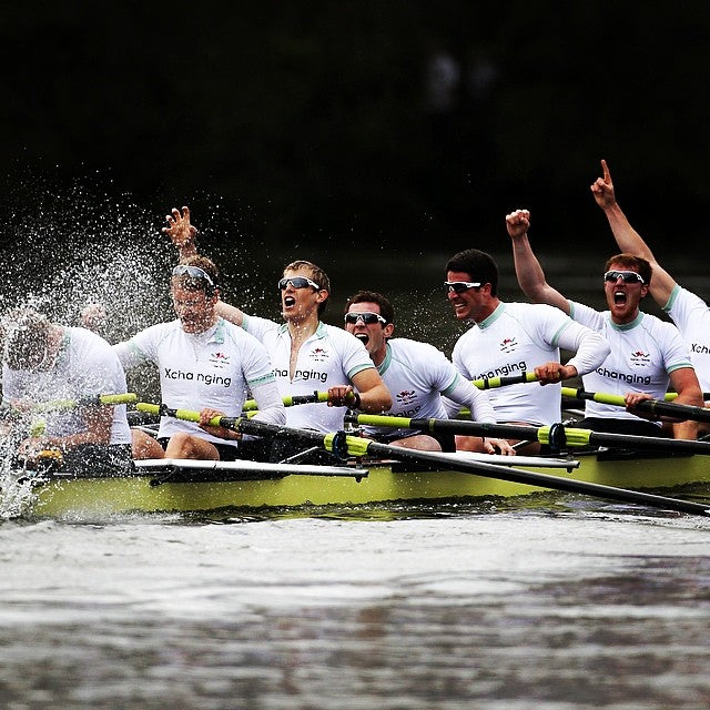 A rowing crew in Pontoon Sports kit celebrating on the water