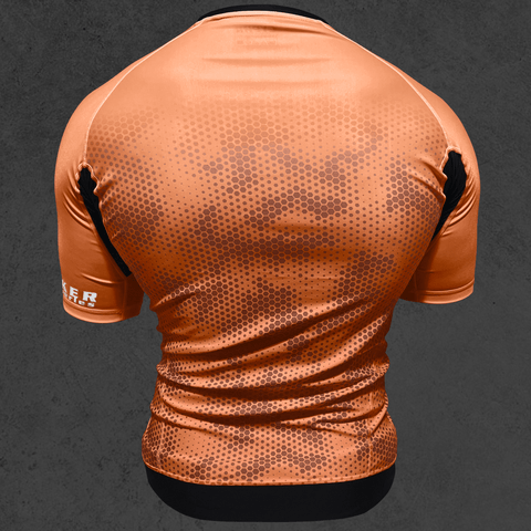 Brown short sleeve BJJ rash guard with hexagon camo design, part of CYPHR Codebreaker Series, shown from the back.