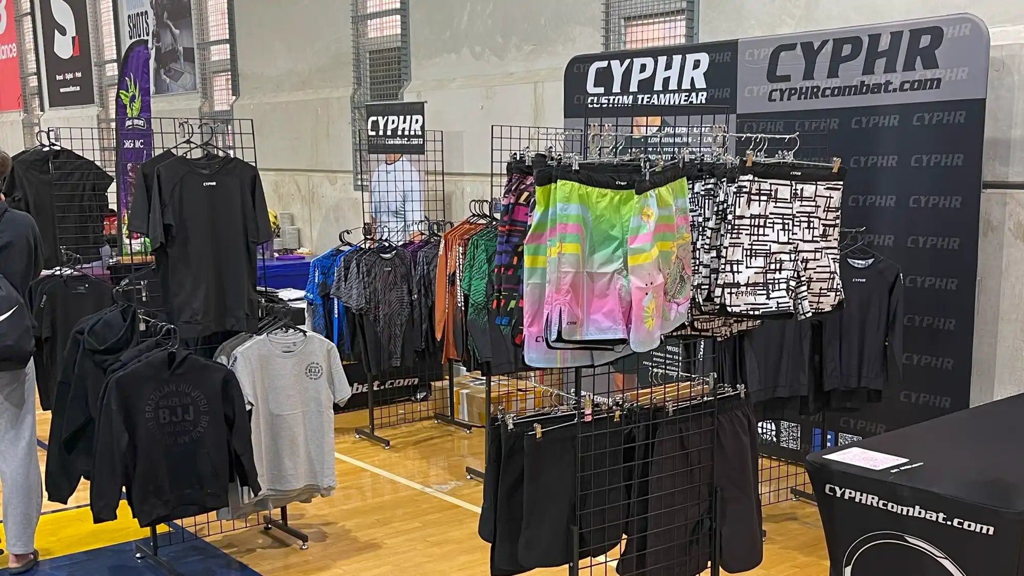 Clothing retail display with racks of t-shirts and apparel in various colors.