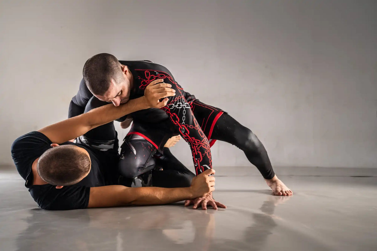 Two martial artists grappling during a Brazilian Jiu-Jitsu match.